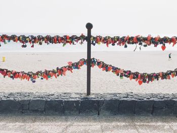 Padlocks on beach against clear sky