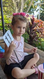 Portrait of cute girl sitting outdoors