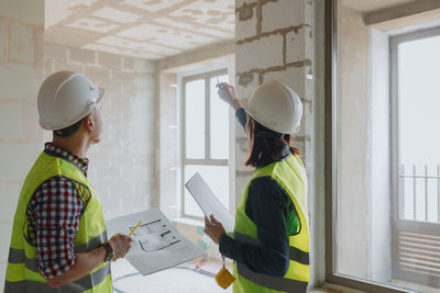 Engineers holding plans at construction site