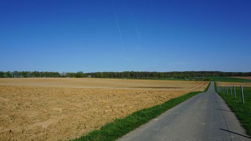 Scenic view of agricultural field against clear blue sky