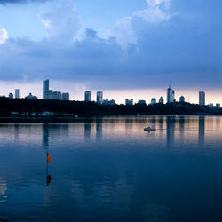 Reflection of buildings in river against sky