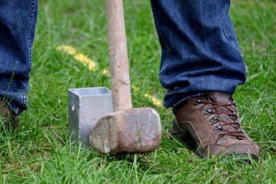 Low section of man standing on field