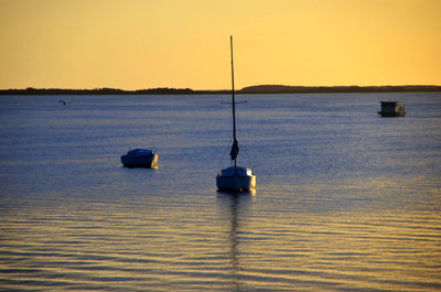 Boat sailing in sea at sunset