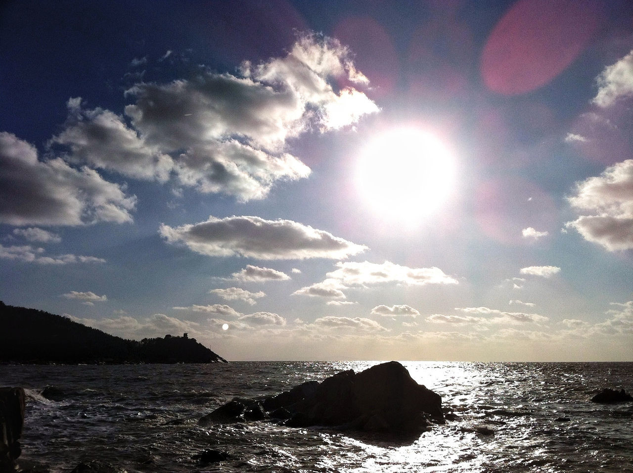 sea, water, sun, horizon over water, scenics, tranquil scene, sky, beauty in nature, sunbeam, tranquility, sunlight, rock - object, nature, lens flare, idyllic, beach, cloud - sky, silhouette, rock formation, shore