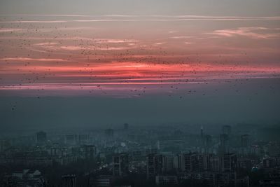 Aerial view of cityscape against sky during sunset