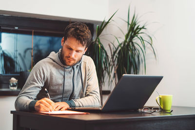 Young man using laptop at home