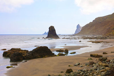 Rocks on beach against sky