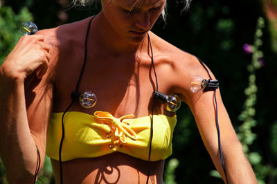 Midsection of woman holding yellow while standing outdoors