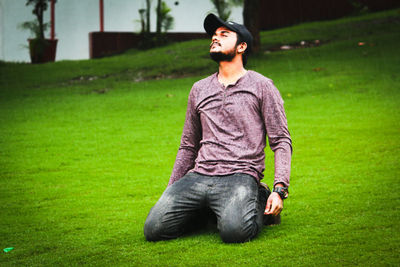 Young man looking away on field