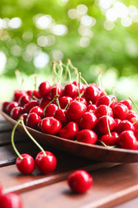 Ripe red berries on a wooden table in a basket. summer background with fruits. cherry harvest.