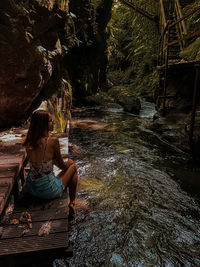 Woman sitting on rock in forest