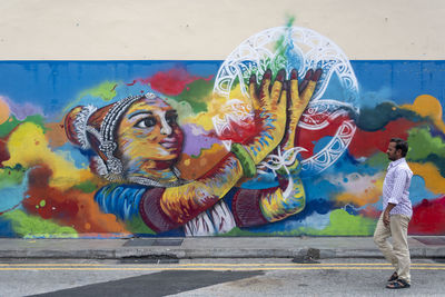 Full length of man with graffiti on wall