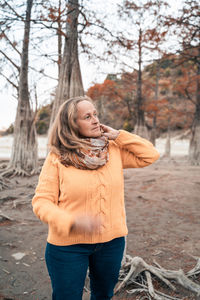 Full length of woman standing by tree in winter