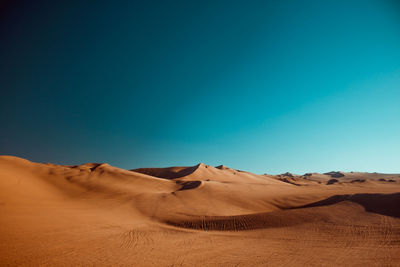 Scenic view of desert against clear blue sky