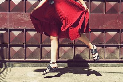 Full length of woman sitting on wall