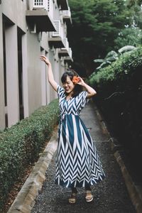 Portrait of smiling young woman standing by plants