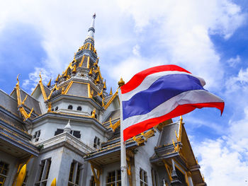 Low angle view of flags on building against sky