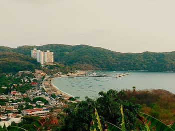 High angle view of city by sea against sky