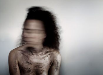 Portrait of shirtless man against white background