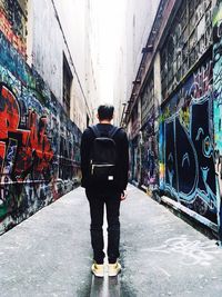 Rear view of man standing in alley