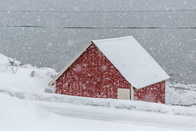 Barn on field during snowfall