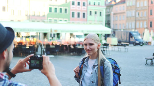 Portrait of woman photographing in city