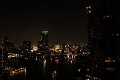 Illuminated buildings in city against sky at night