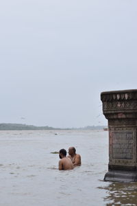 People at beach against clear sky