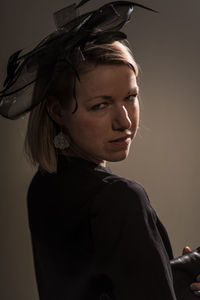 Close-up portrait of young woman against gray background