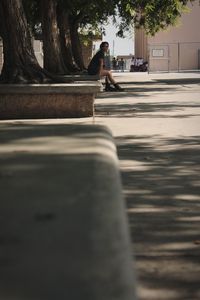 Woman sitting at bottom of a tree staring off