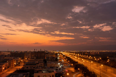 High angle view of illuminated cityscape against sky during sunset