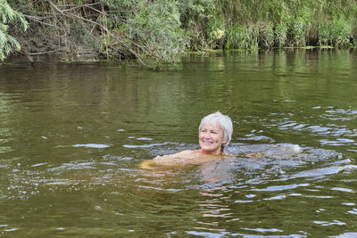 Portrait of woman swimming in lake