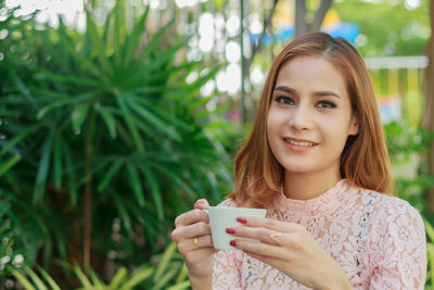 Portrait of smiling young woman coffee cup
