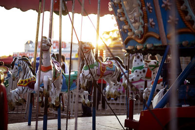 Carousel hanging in amusement park against sky