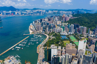 High angle view of city by sea and buildings against sky