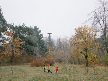 People on field against sky during autumn