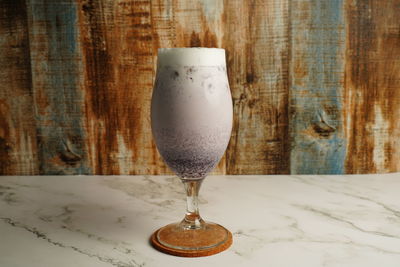 Close-up of wine glass on table against wall