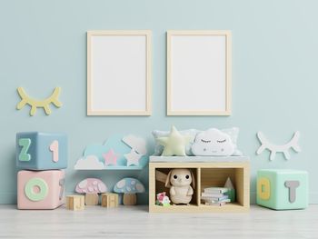 Picture frames hanging on wall with toys on floor