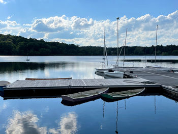 Boats moored in lake against sky