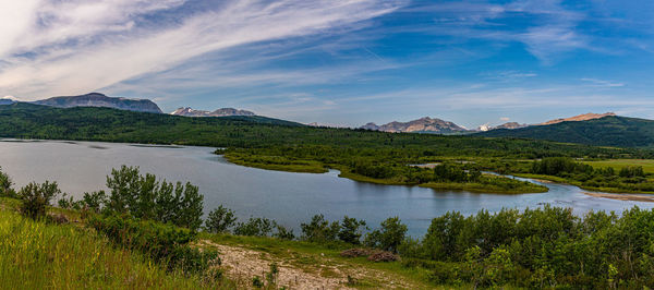 Scenic view of lake by mountains against sky