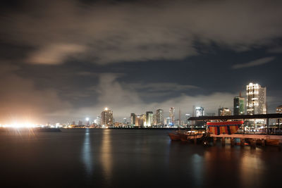 Illuminated buildings in city against sky at night