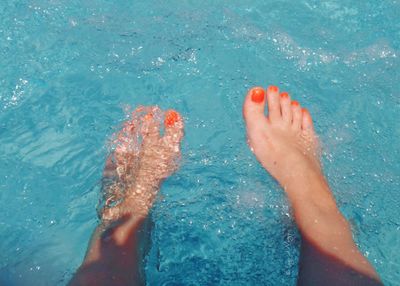 Low section of person standing in swimming pool