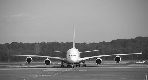 Airplane on runway against sky