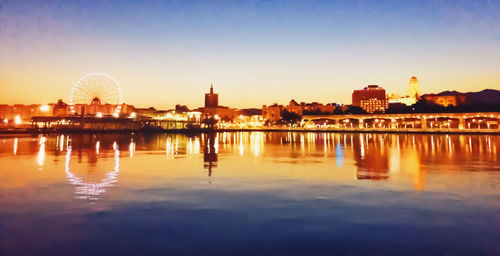 Reflection of buildings in city at sunset