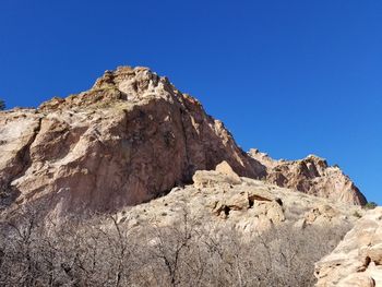 Scenic view of cliff against clear blue sky