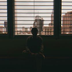 Man looking through window in building