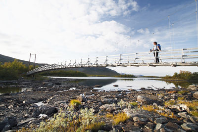 Hiker looking at landscape from footbridge