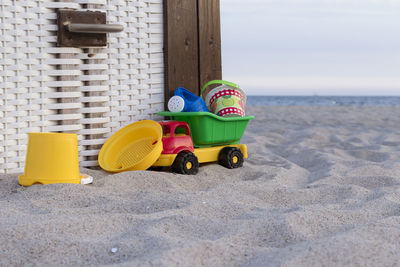 Toys on a beach next to a beach chair 