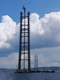 Tower by sea against sky