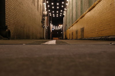 Surface level of empty alley amidst buildings at night